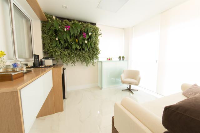 Living integrado com jardim vertical em apartamento reformado em São Paulo
