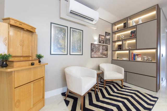Sala de estar com estante planejada e tapete em apartamento reformado em São Paulo